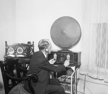 Man operating the controls of a radio