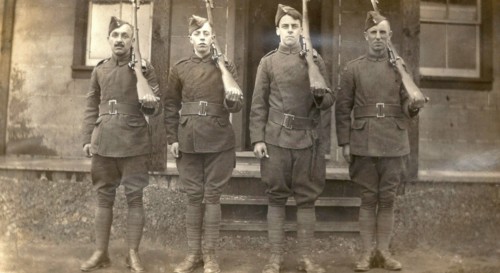 Four airmen holding rifles over their left shoulders