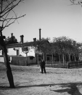 Boy and shy girl in front of building in Israel ca. between 1898 and 1934