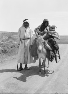 Bedouins in Israel, a woman and infant on donkey, a man standing ca. between 1934 and 1939