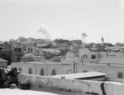 Palestine disturbances during summer 1936 in Jaffa. Troops dynamiting slum section (distant view of smoke in the sky) ca. 1936