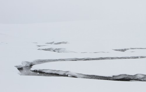 A creek winds through a snowy valley. Antler Creek in Hayden Valley in Yellowstone National Park; Date:  3 February 2015