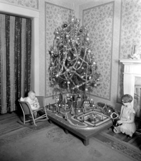Early 20th century Christmas tree in a living room, children looking at toys ca. between 1910 and 1935