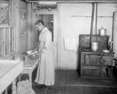 Early 20th century elderly woman working in a kitchen  ca.  between 1910 and 1935