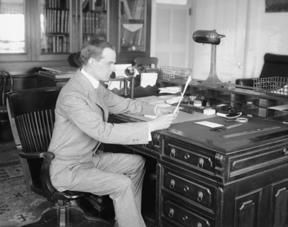 E. Lester Jones reading at his desk  ca.  between 1910 and 1926