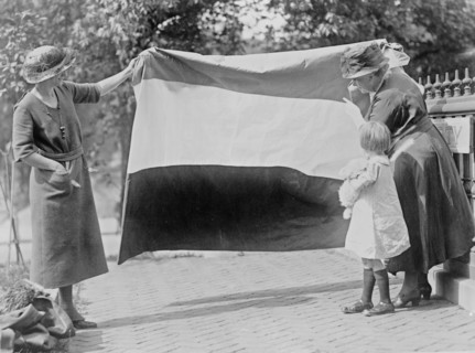 Two suffragettes showing banner to young girl ca. between 1910 and 1930