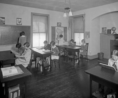 School students doing their lessons at Mrs. Tomlin's School ca.  between 1910 and 1925