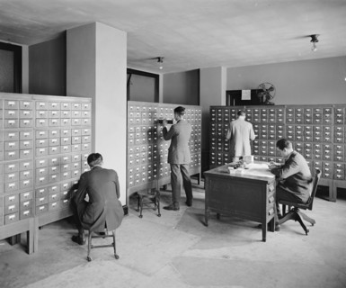 Workers looking at files at the Bureau of Identification ca.  between 1910 and 1926