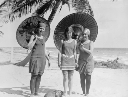 Three women on a beach with umbrellas in the early 20th century ca.  between 1910 and 1920