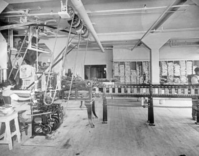 Carton Machine at the C&H Sugar factory. This machine folds, glues, fills, weighs and seals 30 2 lb. or 5 lb. cartons per minute with one operative ca.  between 1910 and 1920