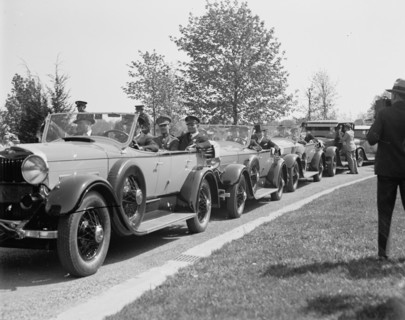 Man photographing line of cars ca. between 1909 and 1923