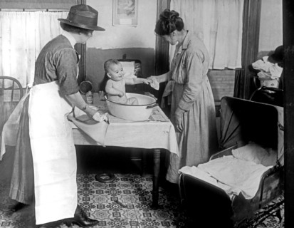 Child Welfare Bureau: Infant Welfare, Parent giving a child a bath ca.  between 1918 and 1928