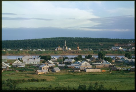 Southwest view, with village on left bank of Varzuga River in foreground, and Church of the Dormition (1674), beyond river in background, Varzuga, Russia; 2001