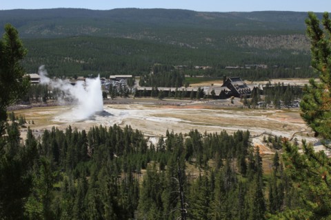 View from Observation Point of visitors watching Old Faithful Geyser with Old Faithful Inn and Old Faithful Visitor Center in background in Yellowstone National Park; Date:  4 August 2013