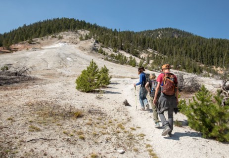 Hikers on a trail going uphill with hydrothermally altered rock all around. Seven Mile Hole Trail in Yellowstone National Park; Date: 11 September 2017