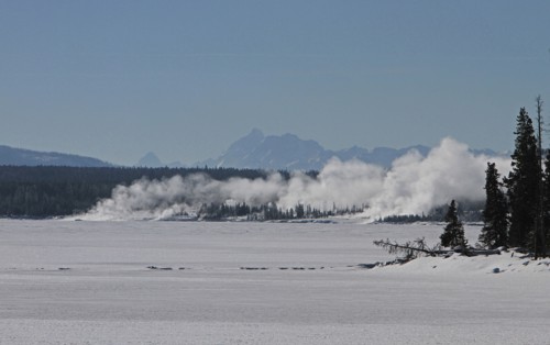 View across Yellowstone Lake to West Thumb Geyser Basin in Yellowstone National Park.  Grand Teton Mountain Range is 50 miles in the distance; Date: 17 January 2014