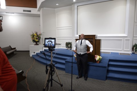 During the Covid-19 pandemic, some churches chose to record sermons to play on their websites and through streaming services to replace in person worship. Here, a technician records a minister as he p...