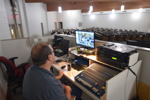 During the Covid-19 pandemic, some churches chose to record sermons to play on their websites and through streaming services to replace in person worship. Here, a deacon of the church looks on as a mi...