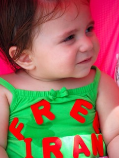 Iranians in Texas taking part in a Freedom for Iran / Green Revolution rally at Dallas City Hall plaza in downtown Dallas, TX; young child wearing a Free Iran top ca. June 2009