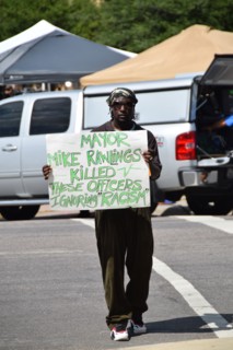 Dallas, Texas, USA. 10th July, 2016 An African American man holds a counter protest sign at a gathering of citizens in front of Dallas police headqurters who have come to show support for the police