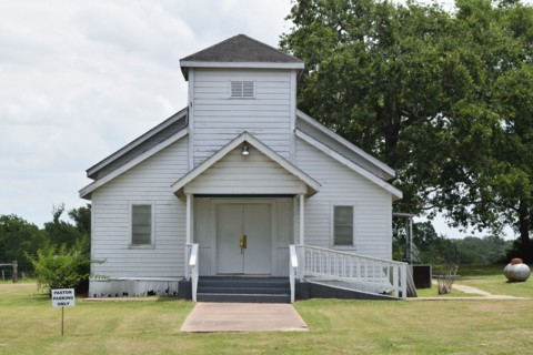 Old white church building NE of Brenham, TX, pastor parking only sign in lower left side of image