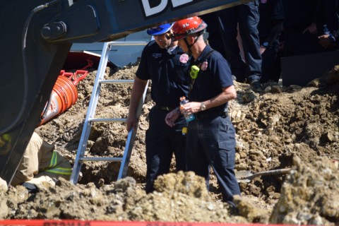 First responders; firemen and paramedics, help trapped construction worker trapped in a trench; Irving, TX USA
