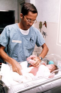 Worker changing the diaper of a newborn baby