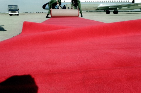 Airmen place a red carpet on the ground