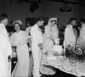 Bride cutting cake at wedding reception