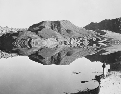 Landscape with man viewing mountain reflection