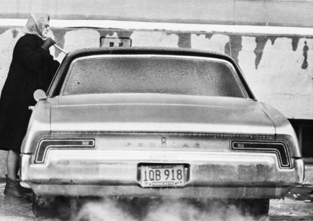 Woman Chipping Ice from Car Windshield 1969