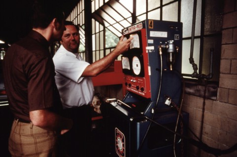 Worker shows a man that his car had passed an emissions test