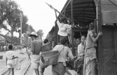 Indonesian travelers board a train at Madioen in Indonesia, Dutch East Indies ca. 1949