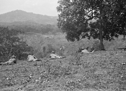 Soldiers lie on the ground in position and overlook a valley in Bandung, Indonesia, Dutch East Indies ca. 1946