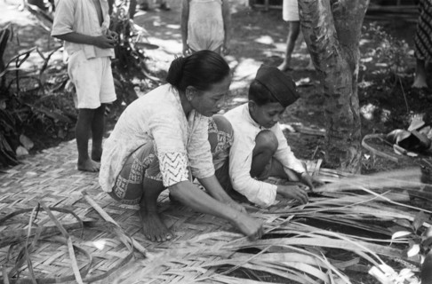 Street scenes. Woman and boy busy braiding a screen of atap leaves; Date 24 August 1948 Location Indonesia, Dutch East Indies