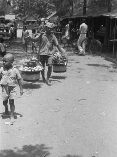 Vegetable seller with baskets on yoke; Date 1947; Location Indonesia, Dutch East Indies