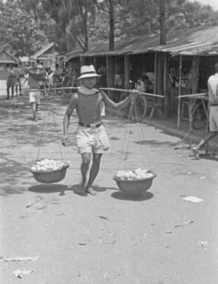 1947 -Fruit seller with baskets on yoke in Indonesia, Dutch East Indies