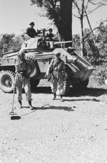 Soldier with a metal detector in search of land mines. Behind him a Humber armored car; Date June 1947; Location Indonesia, Dutch East Indies