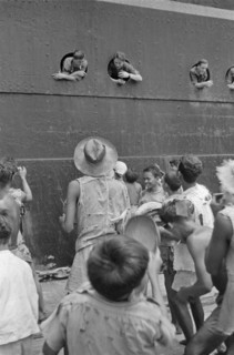 November 1946 - Soldiers throw cigarettes from the portholes for the children on the quay - Location: Batavia, Indonesia, Jakarta, Dutch East Indies, Tandjong Priok