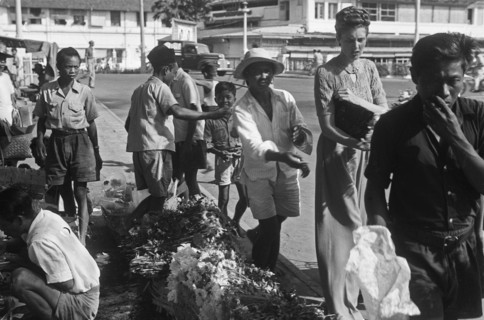 1940s Indonesia - Street scenes. A Dutch woman buys flowers from a florist - 24 August 1948