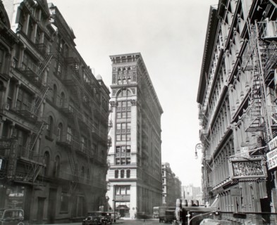 1930s New York City - Looking down Broadway, ornate Bank of Sicily Trust near center of image, sign for vegetarian restaurant, right, cars and trucks, Broadway near Broome Street, Manhattan ca. 1935