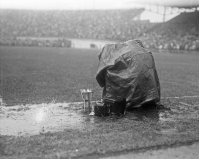 September 21, 1947 - Reporters covering a soccer match in Amsterdam take cover from the rain