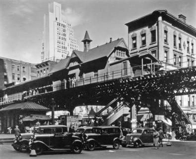 Elevated railroad station in Hanover Square in Lower Manhattan, cars below, buildings of various eras beyond ca. 1936