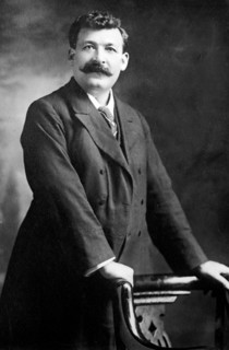 Gipsy Smith, standing next to chair, 1908