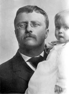 Theodore Roosevelt, holding child
