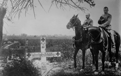 German soldiers on horseback mourning at graves of soldiers on the battlefield during World War I ca. 1914-1915