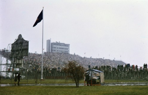 View of crowd in stands and parked cars at Beaver Stadium for Penn State football game (December 1962)