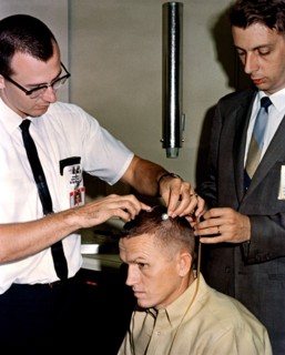 (2 Dec. 1965) Astronaut Frank Borman, Gemini-7 command pilot, sits attentively as two scalp electrodes are attached to his head.