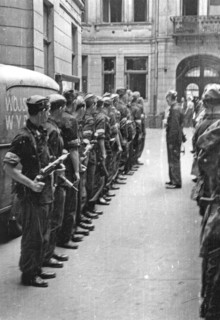 Warsaw Uprising: Debriefing of II platoon Oddzialu Oslonowego WZW „Chwaty” under command of Stefan Berent „Steb” in the courtyard of a townhouse at Bowdena Street. In the back visible a car with “WZW”...
