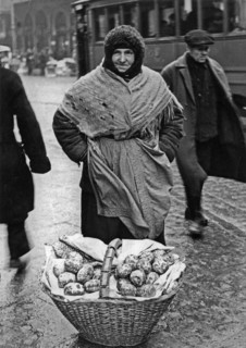 A woman selling paczki (filled doughnuts) in a street in Warsaw ca. December 1934